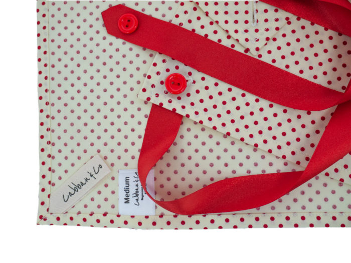 Cream with Red Spot Fabric Gift wrapping showing ribbons and buttons and mitred corners