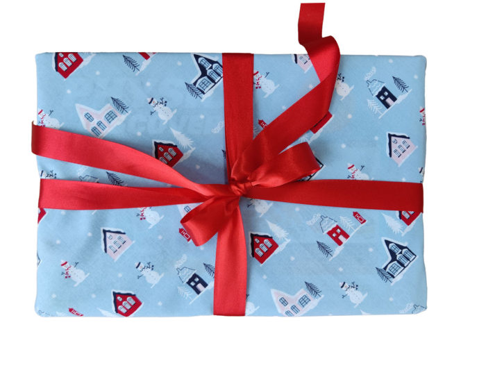 Gift wrapped with Light Blue Little Town Christmas Fabric Wrapping and Red Ribbon