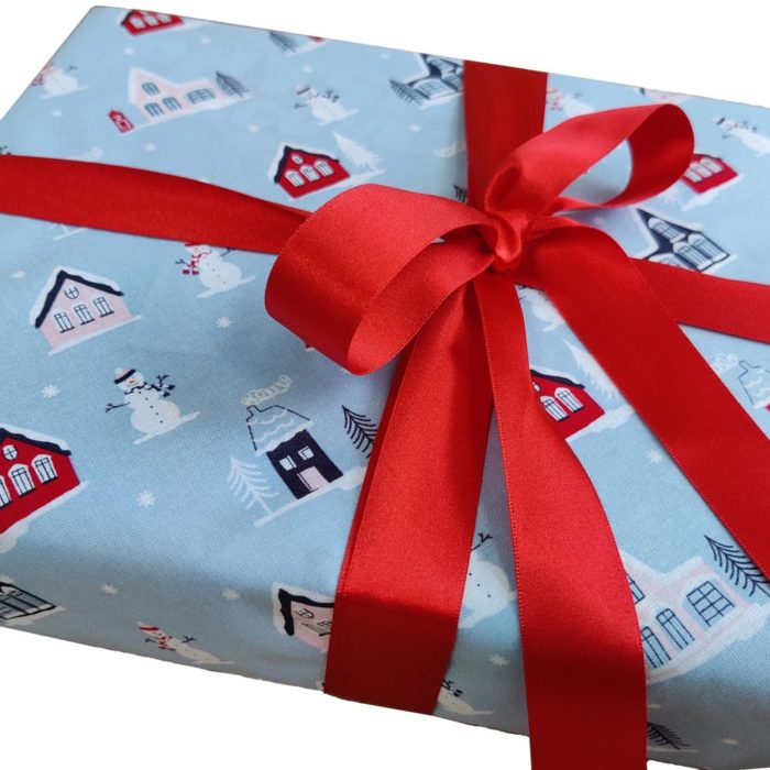 Gift wrapped with Light Blue Little Town fabric wrap and red ribbon