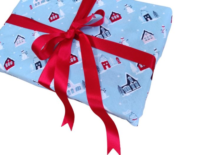 Gift wrapped with Light Blue Little Town fabric wrap and red ribbon