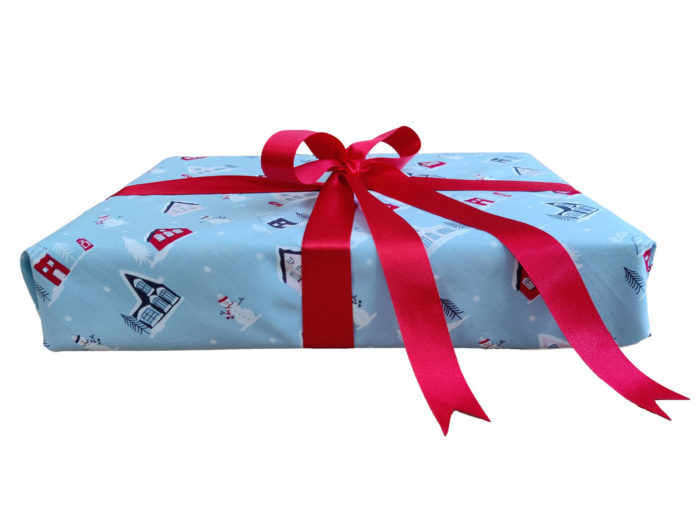 Present wrapped with Light Blue Little Town Christmas Fabric Wrap and Red Ribbon